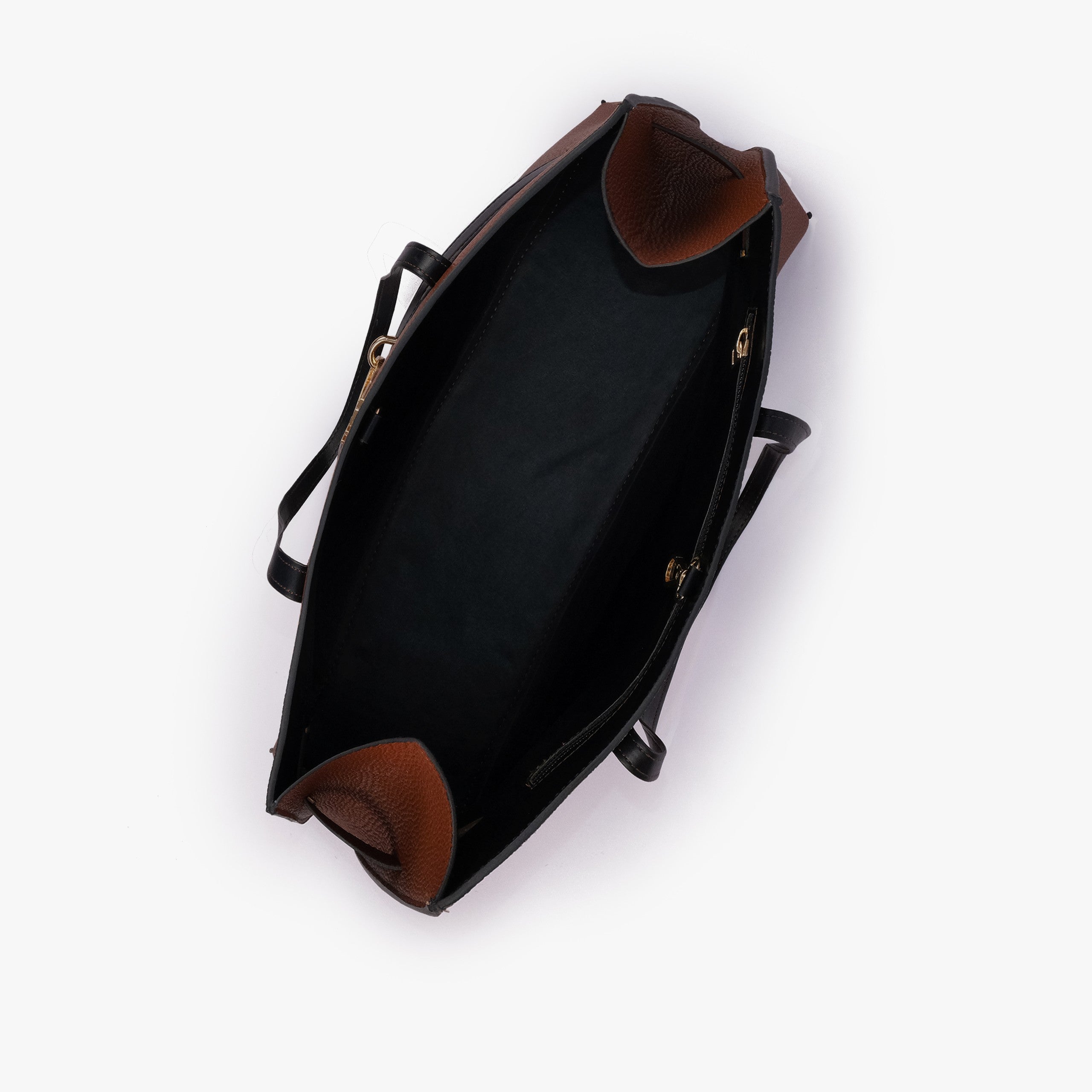 Brown cognac Monday Tote — interior top-down view showing smooth black lining, cognac pebbled wing-cut corner folds, back-wall zipper with gold runner