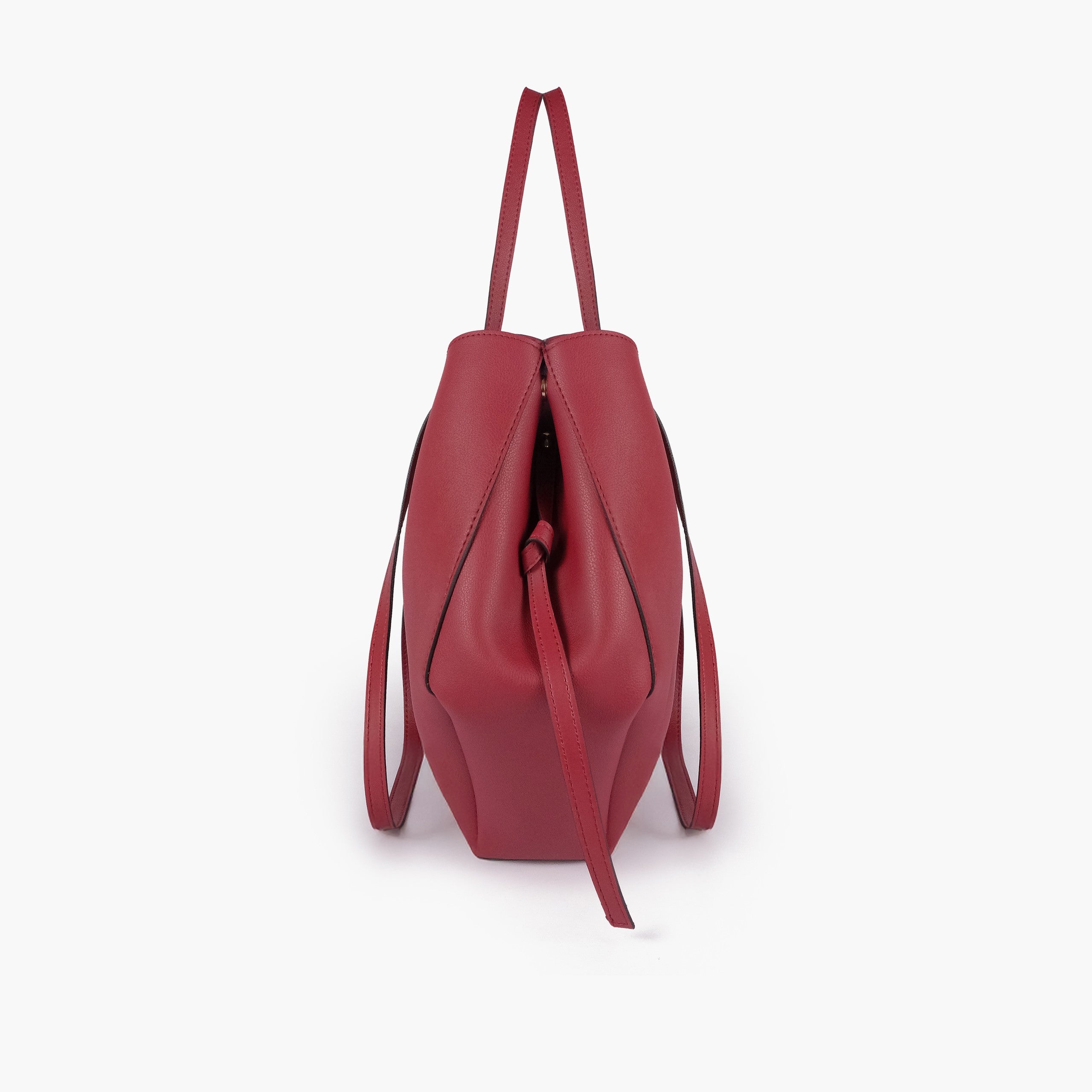 Maroon atelier tote — side profile showing wing-cut origami fold, cinch tie, and slim shoulder handle