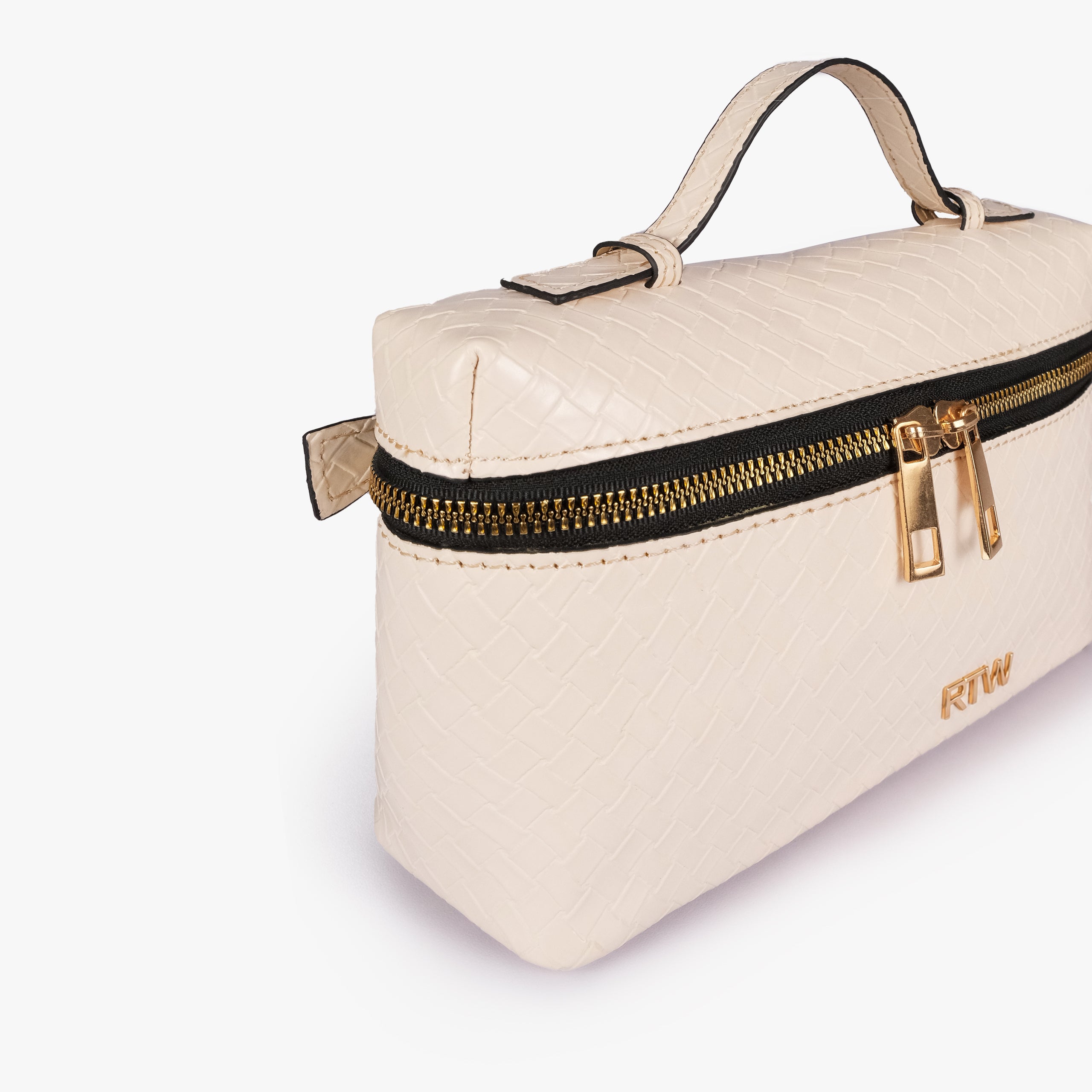 Cream weave vanity top-handle bag — closeup of the diamond-quilted faux-leather finish, stitching, dark zipper tape, gold-tone zipper pulls, and small front hardware mark
