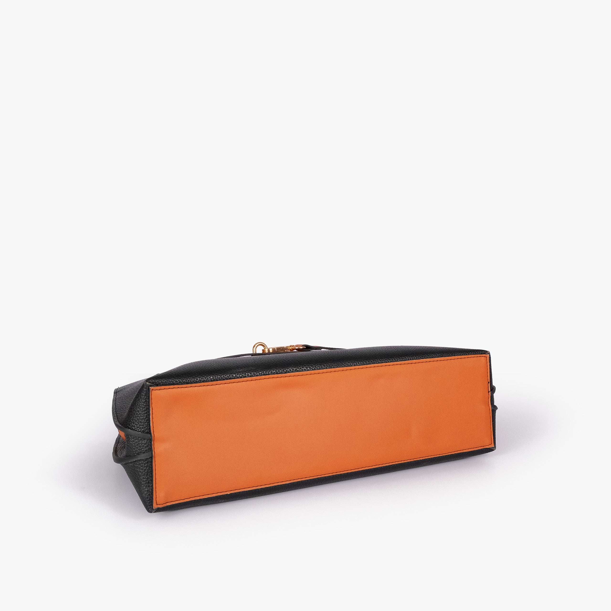 Black Monday Tote — underside tilted view showing reinforced burnt orange smooth base panel and black pebbled sides