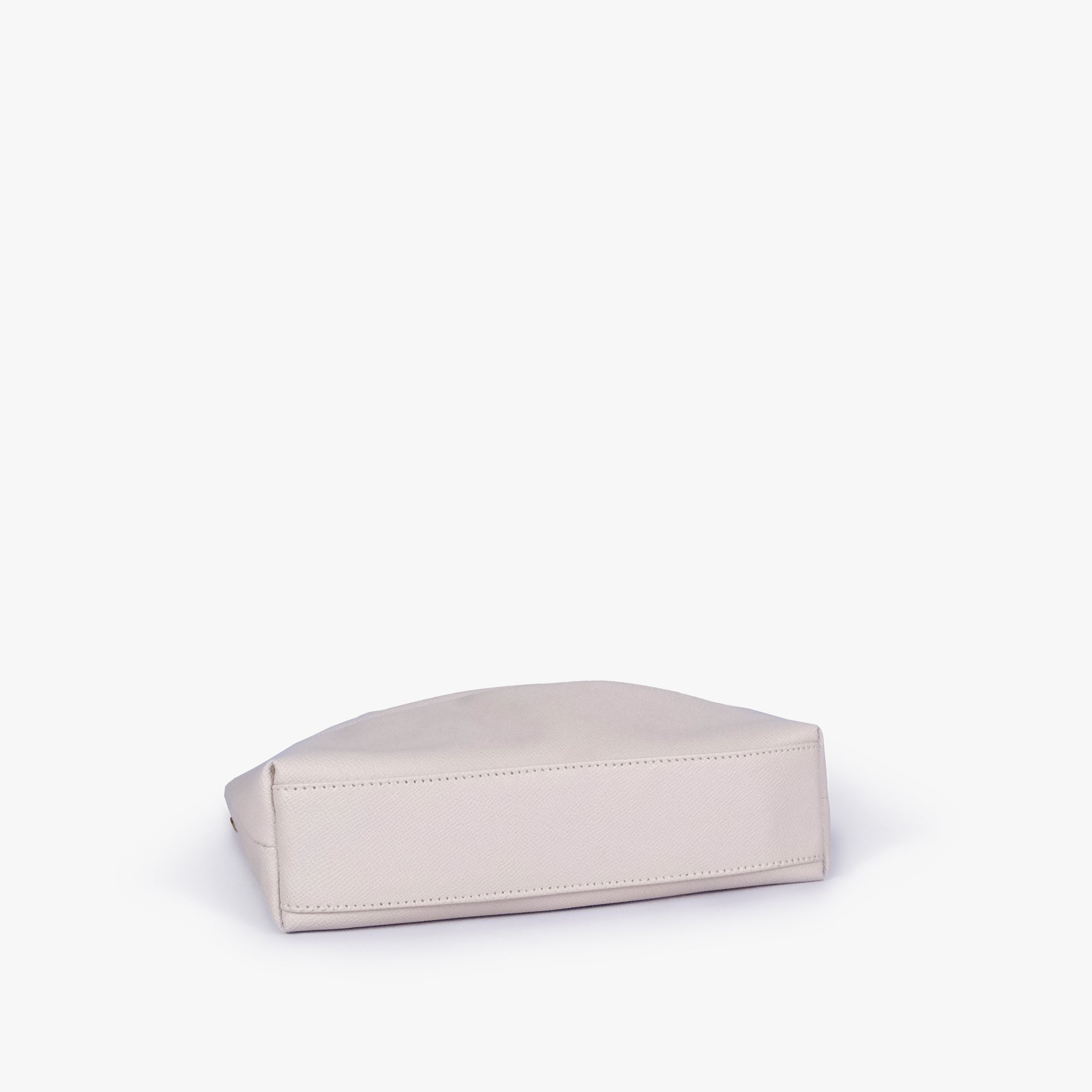 Cream pleated clutch bag with chain — bottom view showing the stitched flat base and slim depth, soft ivory cream