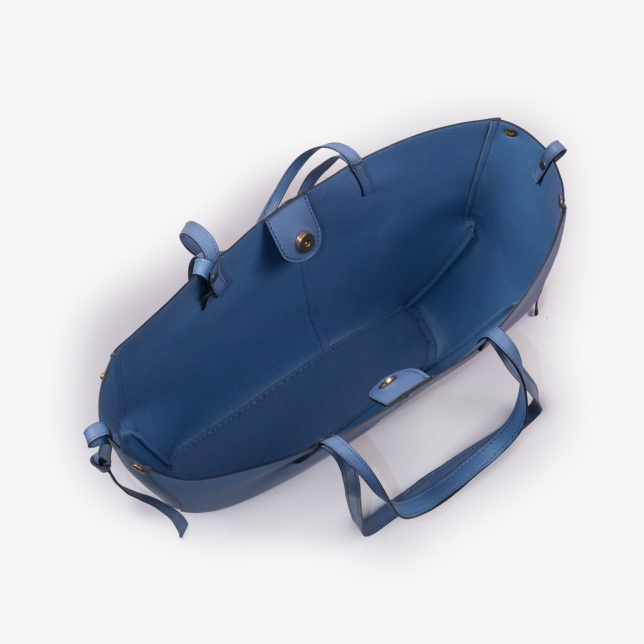 Sky blue atelier tote — interior top-down view with smooth deeper navy-blue faux leather lining, center divider panel, gold magnetic snap