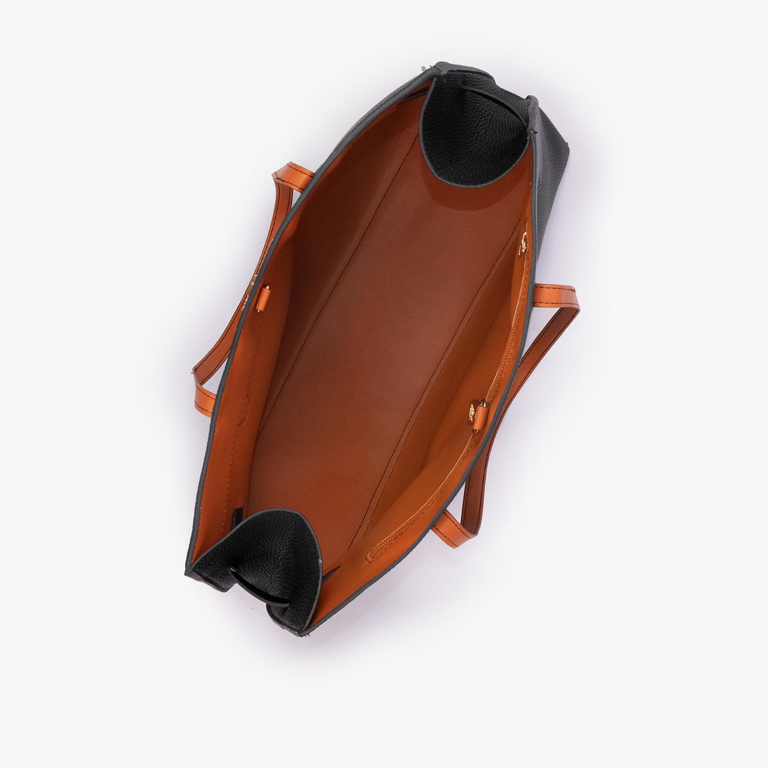 Black Monday Tote — interior top-down view showing smooth burnt orange lining, black pebbled wing-cut corner folds, back-wall zipper with gold runner