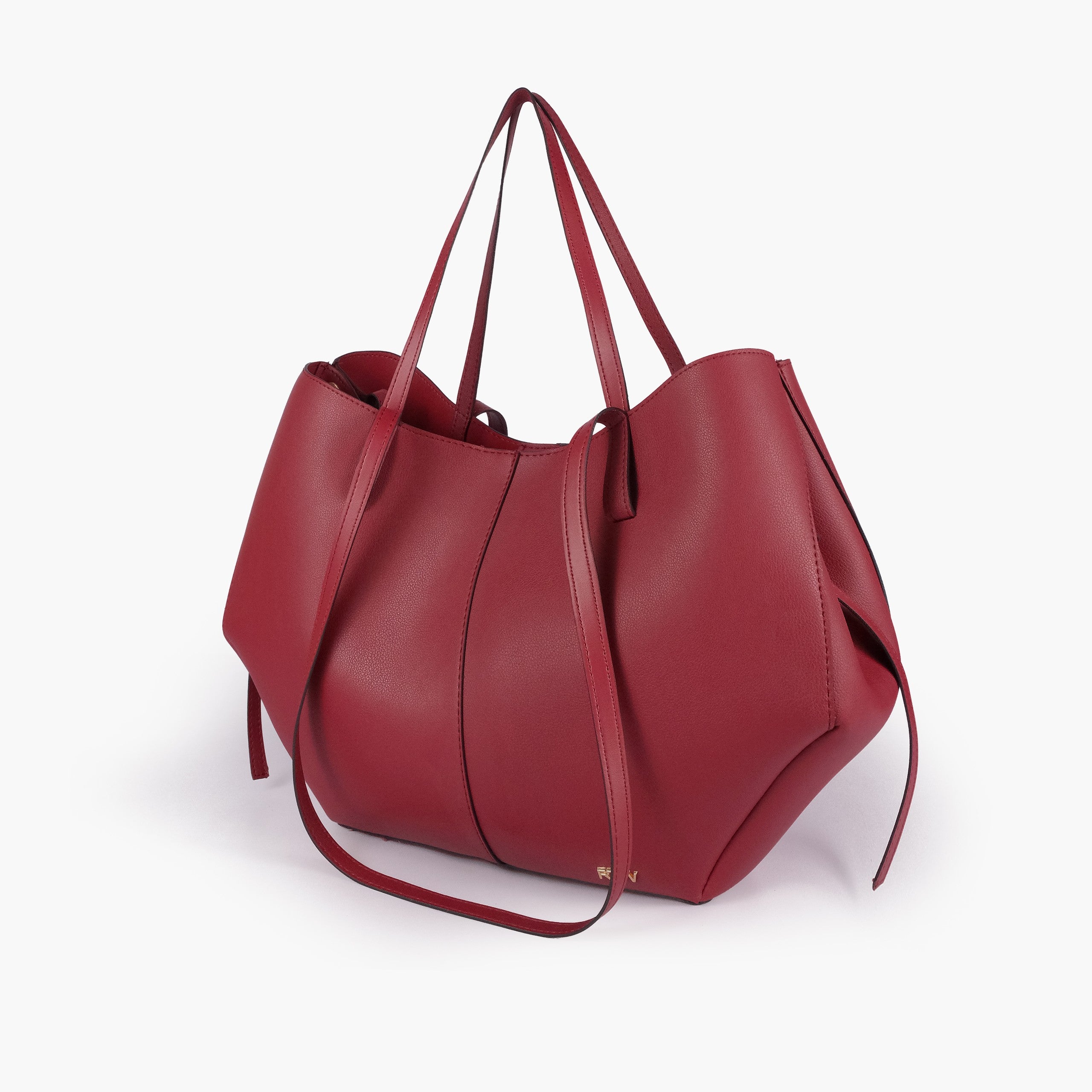Maroon atelier tote — hero 3/4 quarter view, deep burgundy wine smooth faux leather, wing-cut origami side panels, slim handles, gold RTW logo at front base