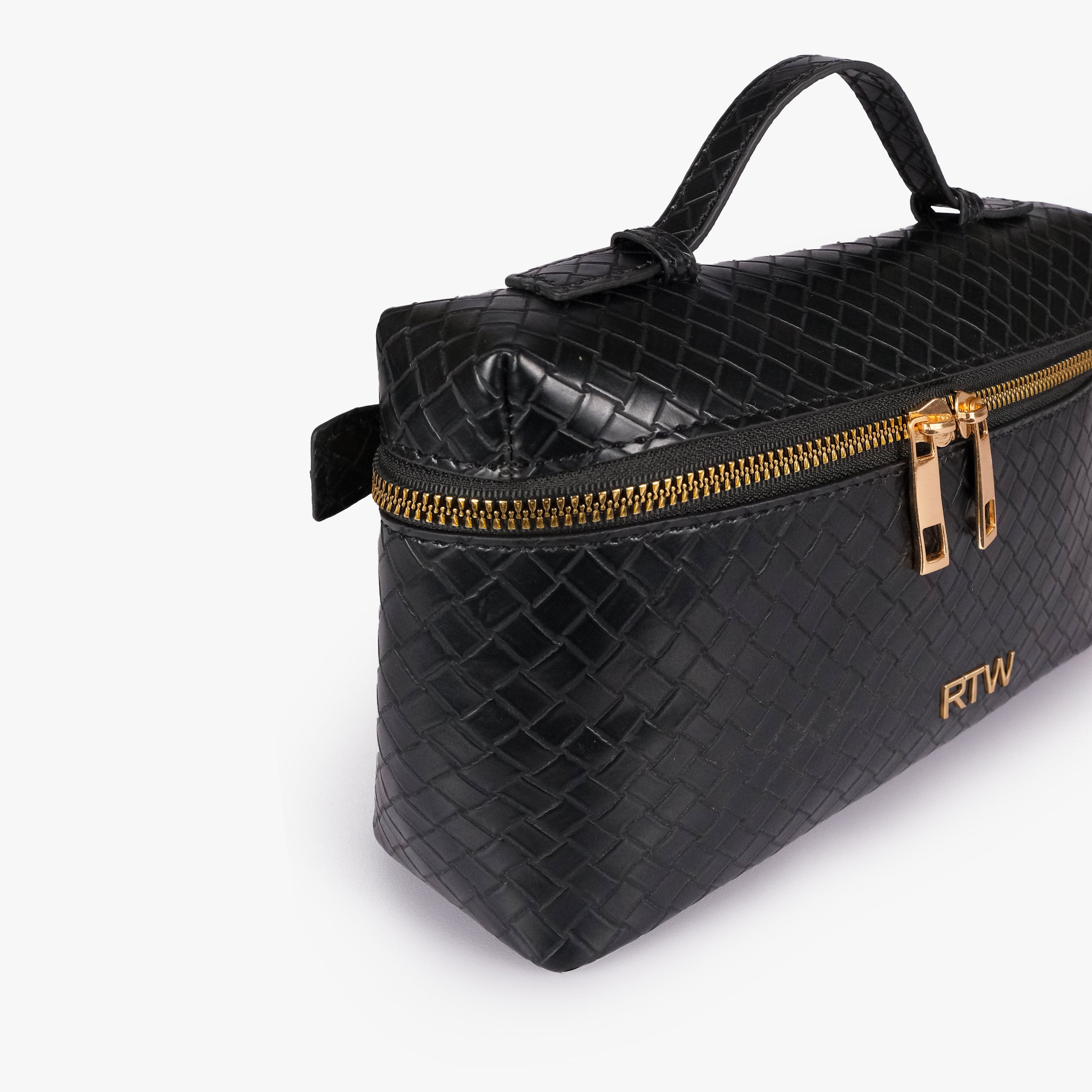 Black weave vanity top-handle bag — closeup of the diamond-quilted faux-leather finish, stitching, dark zipper tape, gold-tone zipper pulls, and small front hardware mark