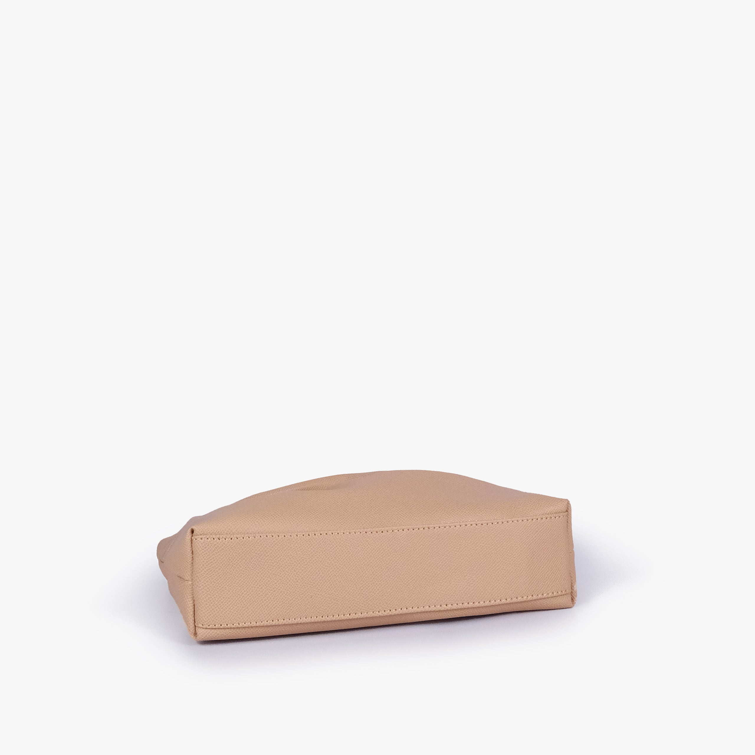 Beige pleated clutch bag with chain — bottom view showing the stitched flat base and slim depth, warm pale beige