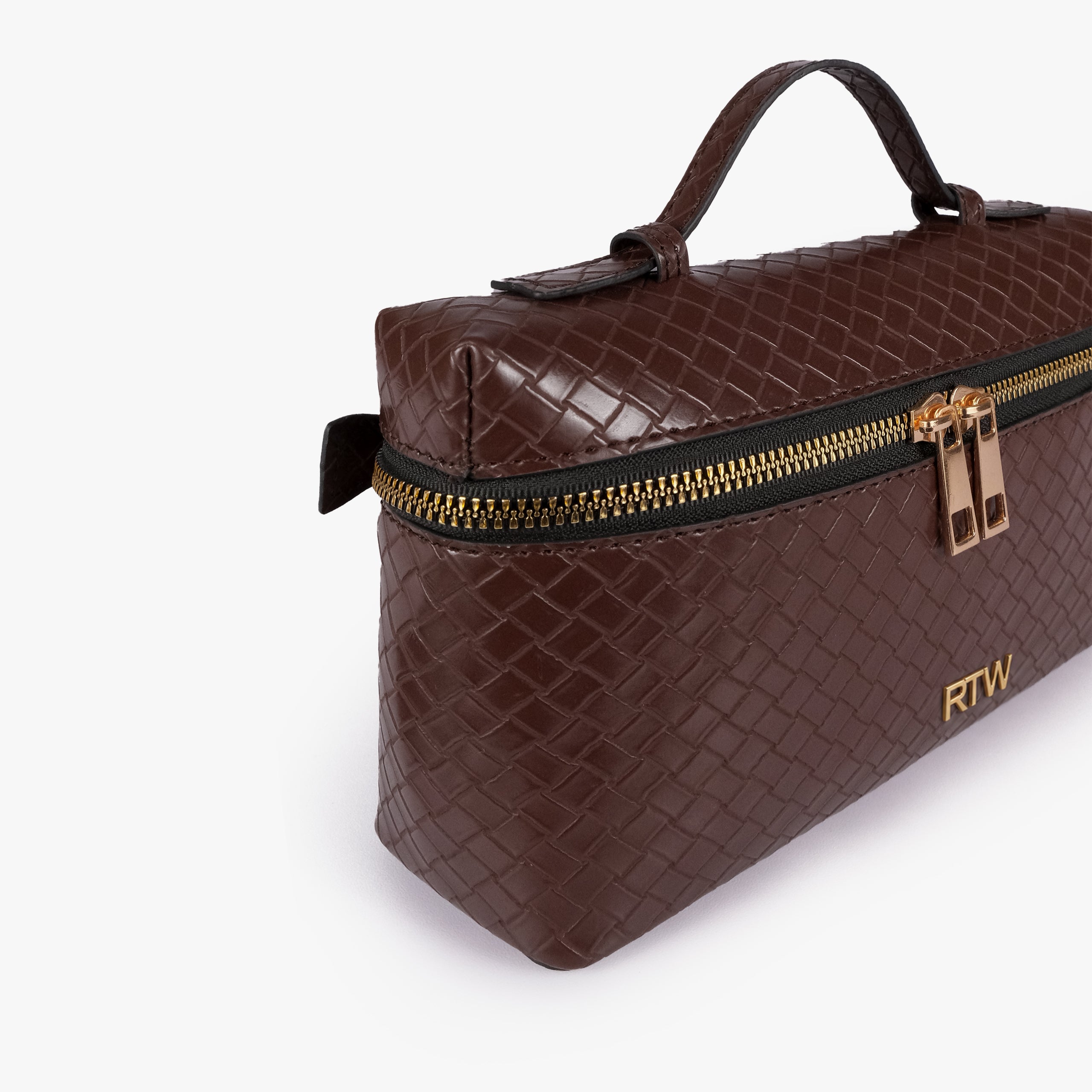 Chocolate brown weave vanity top-handle bag — closeup of the diamond-quilted faux-leather finish, stitching, dark zipper tape, gold-tone zipper pulls, and small front hardware mark