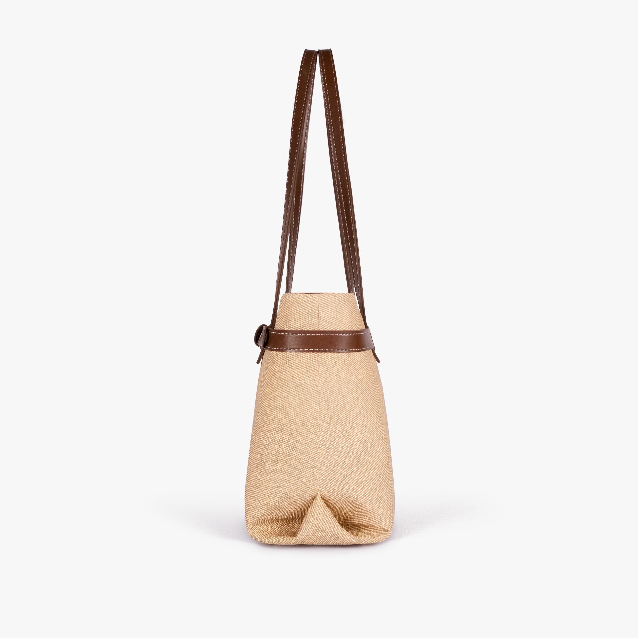 Brown belted tote bag — side profile showing the slim depth, folded side gusset, smooth trim edge, and long shoulder handle drop, cream-tan textured body with brown smooth faux-leather trim